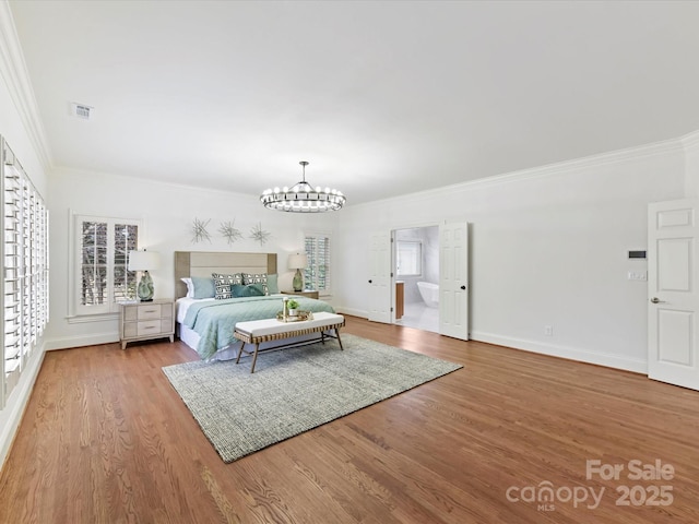 bedroom with ornamental molding, wood finished floors, baseboards, and a chandelier