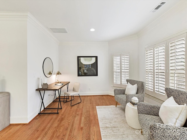 sitting room with visible vents, crown molding, baseboards, and wood finished floors