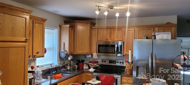 kitchen featuring appliances with stainless steel finishes, sink, and dark stone counters