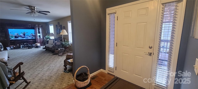 carpeted foyer entrance featuring ceiling fan