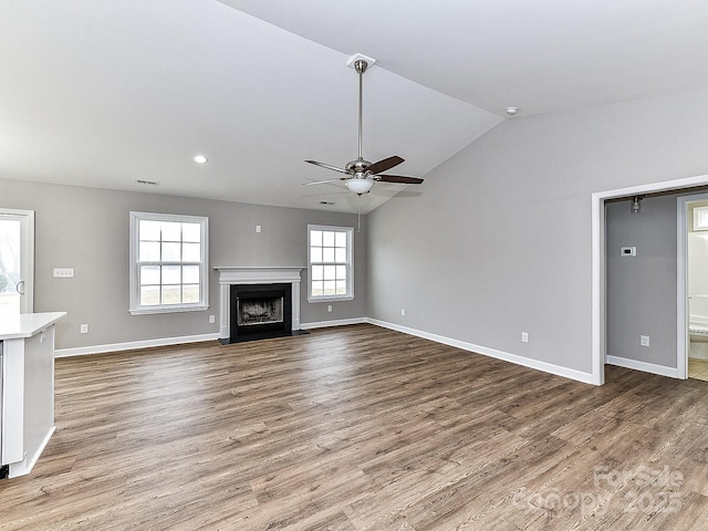 unfurnished living room featuring ceiling fan, lofted ceiling, and hardwood / wood-style floors