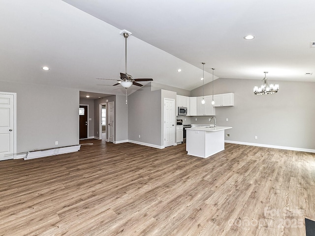 unfurnished living room with sink, ceiling fan with notable chandelier, vaulted ceiling, and light hardwood / wood-style floors