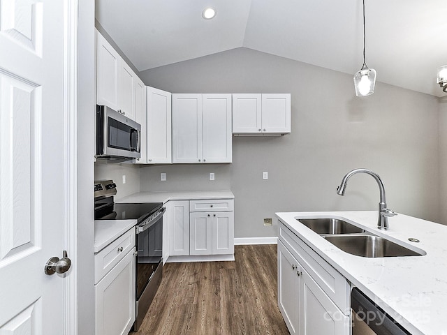 kitchen featuring vaulted ceiling, appliances with stainless steel finishes, sink, white cabinets, and hanging light fixtures