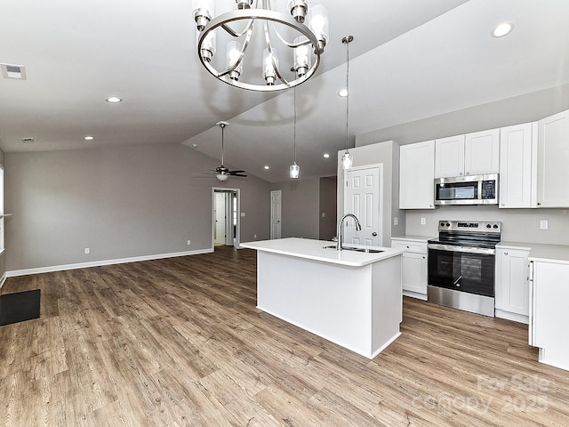 kitchen with sink, hanging light fixtures, stainless steel appliances, a kitchen island with sink, and white cabinets