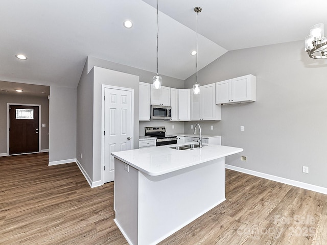 kitchen with sink, white cabinetry, an island with sink, hardwood / wood-style flooring, and stainless steel appliances