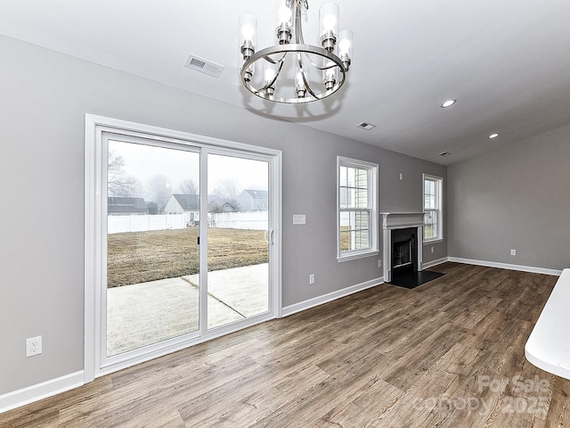 unfurnished living room featuring hardwood / wood-style floors and an inviting chandelier