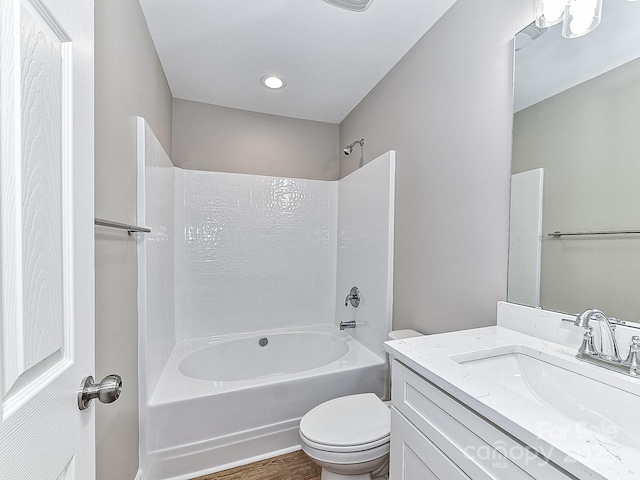 full bathroom featuring hardwood / wood-style flooring, toilet, vanity, and shower / bathing tub combination