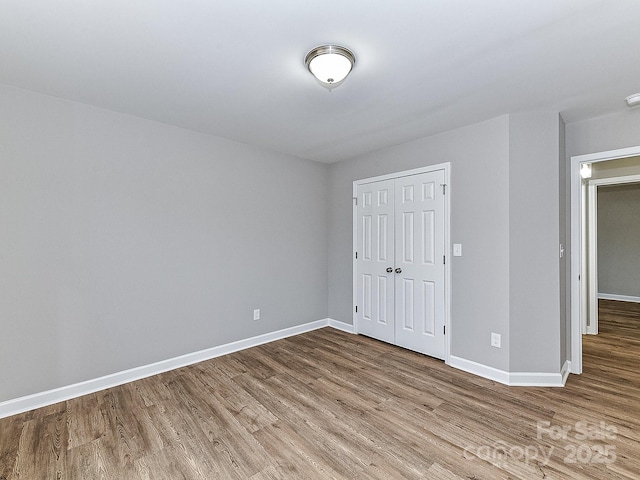 unfurnished bedroom featuring wood-type flooring and a closet