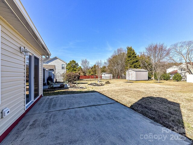 view of yard with a storage unit and a patio area