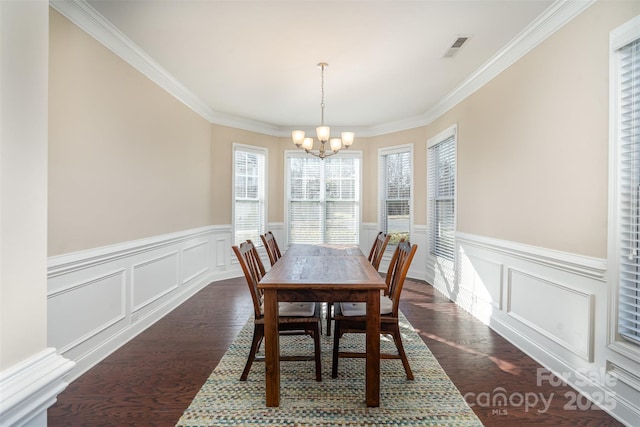 dining space featuring dark hardwood / wood-style flooring, a notable chandelier, and ornamental molding