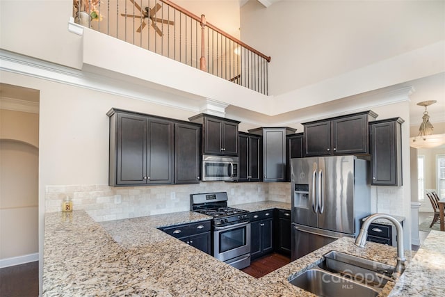 kitchen with stainless steel appliances, sink, and light stone counters