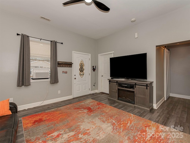 living room featuring dark wood-style floors, visible vents, ceiling fan, and baseboards