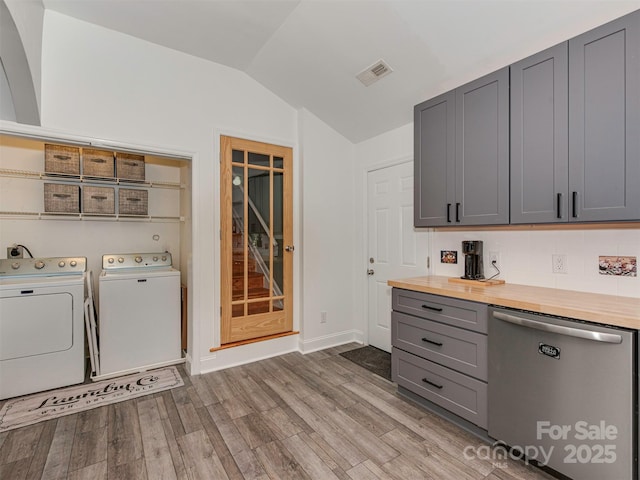 laundry room featuring laundry area, light wood finished floors, baseboards, visible vents, and independent washer and dryer