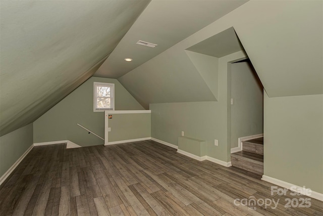 bonus room featuring lofted ceiling, baseboards, visible vents, and wood finished floors