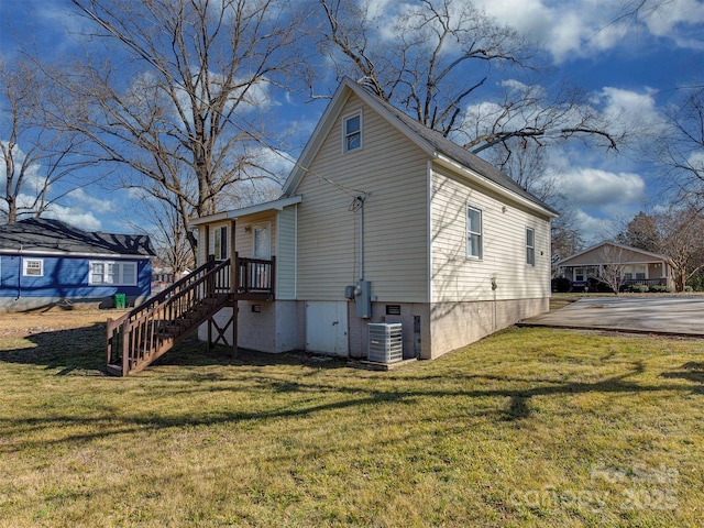 view of home's exterior featuring a yard, stairway, and cooling unit