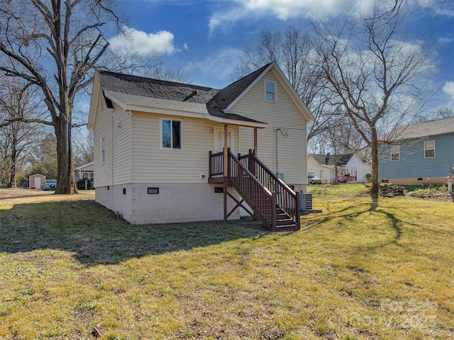 rear view of house featuring cooling unit, roof with shingles, and a yard