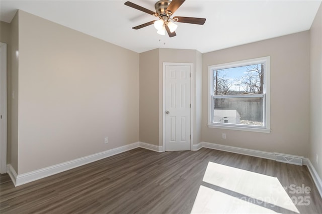 spare room with dark hardwood / wood-style floors and ceiling fan