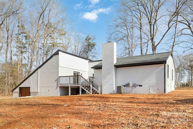 back of house with cooling unit and a wooden deck