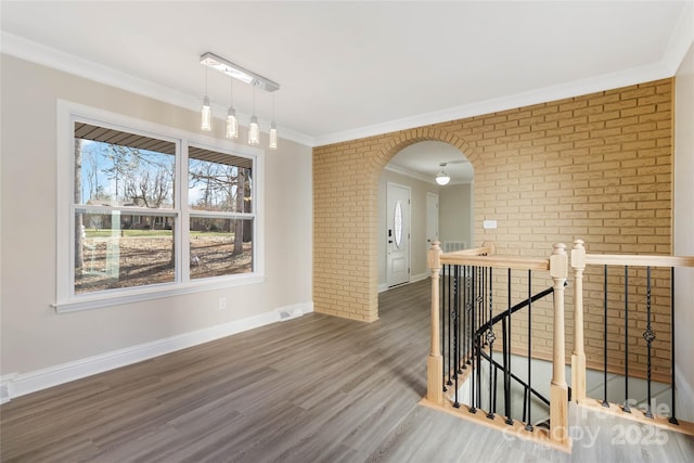 spare room with ornamental molding, brick wall, and dark hardwood / wood-style floors