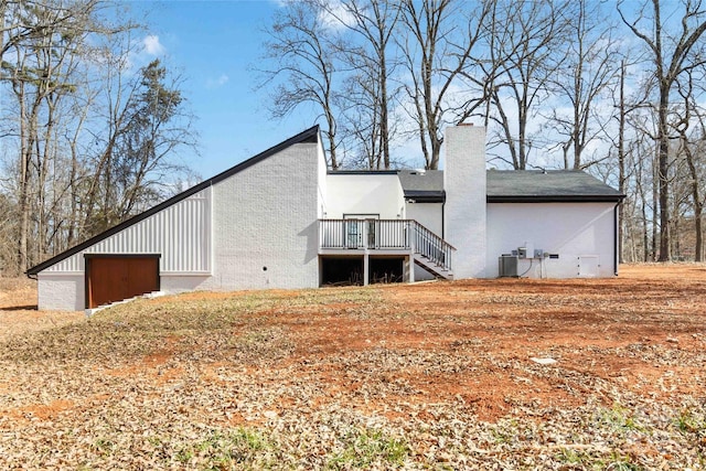 rear view of house with a wooden deck and central AC