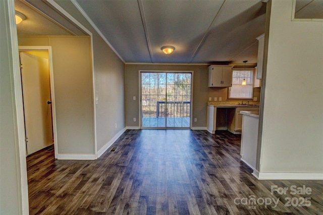 unfurnished living room featuring ornamental molding and dark hardwood / wood-style flooring