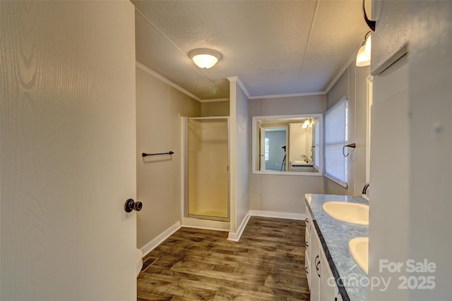 bathroom with hardwood / wood-style flooring, vanity, walk in shower, crown molding, and a textured ceiling