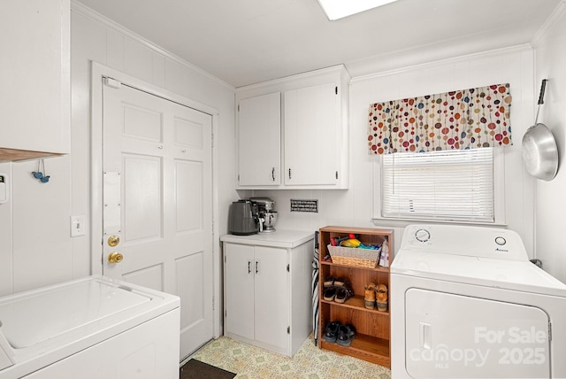 clothes washing area with separate washer and dryer, ornamental molding, and cabinets