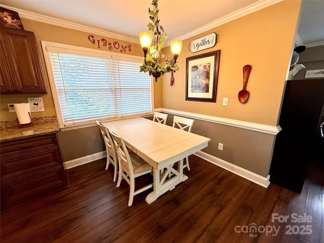 dining room with dark wood-type flooring, crown molding, and a notable chandelier