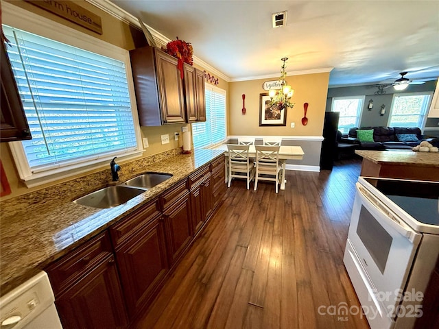 kitchen with dark hardwood / wood-style floors, pendant lighting, sink, ornamental molding, and light stone countertops