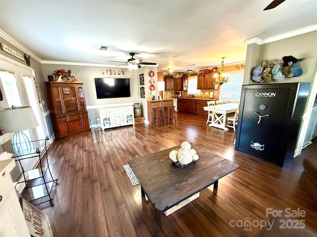 living room featuring sink, ceiling fan with notable chandelier, ornamental molding, and dark hardwood / wood-style floors