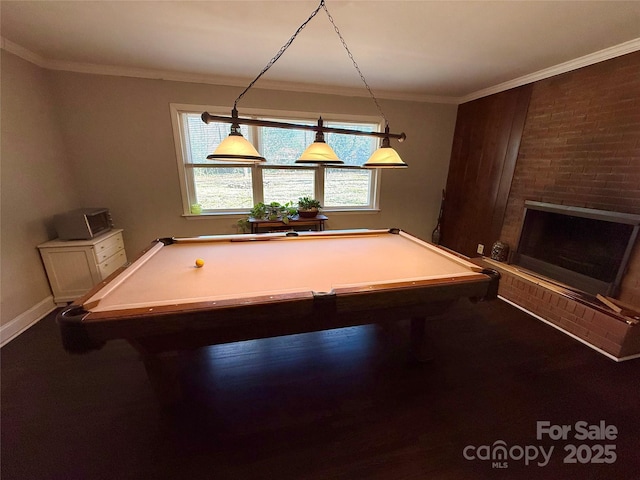 recreation room with a brick fireplace and crown molding