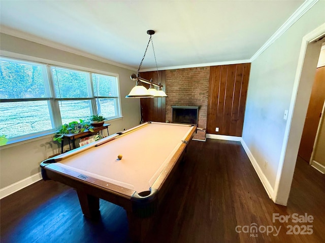 playroom featuring dark wood-type flooring, pool table, crown molding, and a brick fireplace