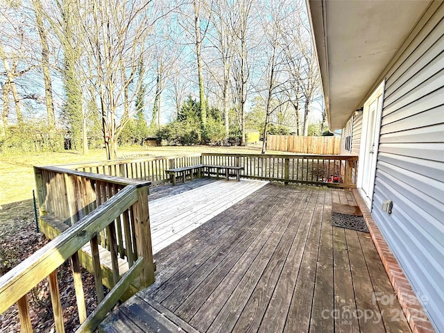 wooden terrace featuring a lawn