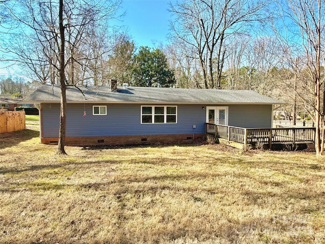 back of house featuring french doors, a wooden deck, and a lawn