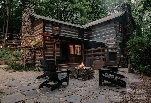 back of house featuring an outdoor fire pit and a patio area