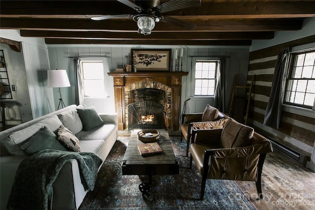 living area featuring hardwood / wood-style floors, beamed ceiling, and ceiling fan