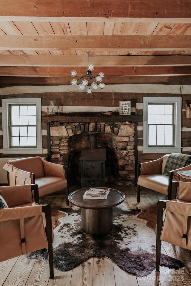 living room with hardwood / wood-style flooring, a wood stove, wood ceiling, and beam ceiling