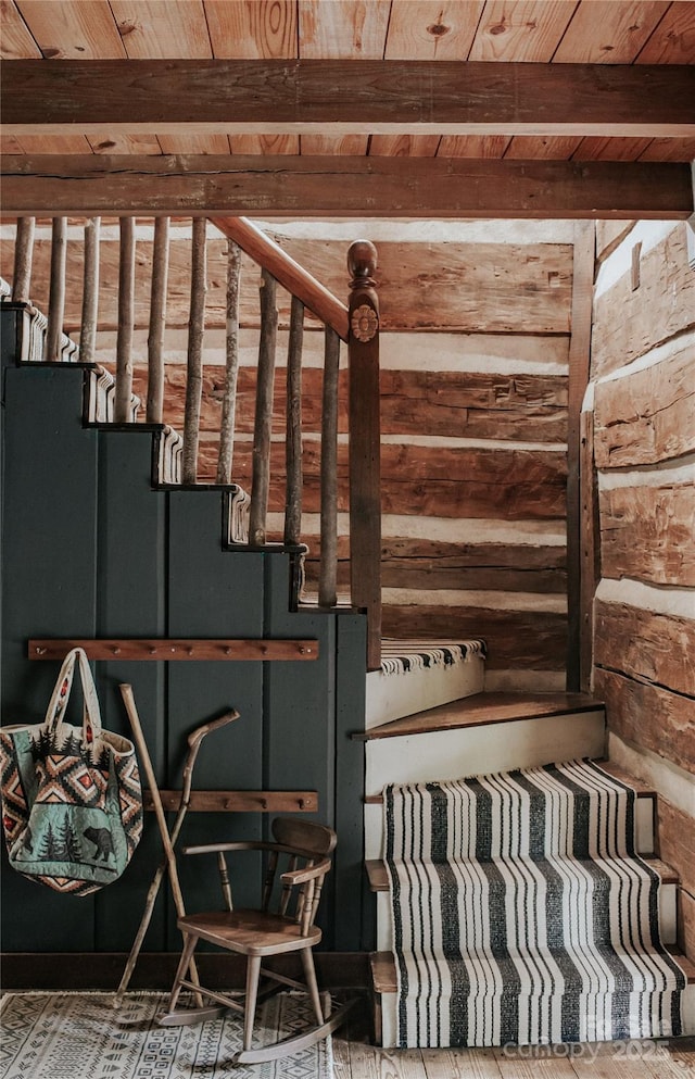 interior space with beam ceiling, wood ceiling, and wood walls