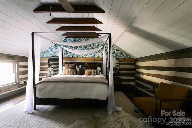 bedroom with wood ceiling, vaulted ceiling, and wood walls