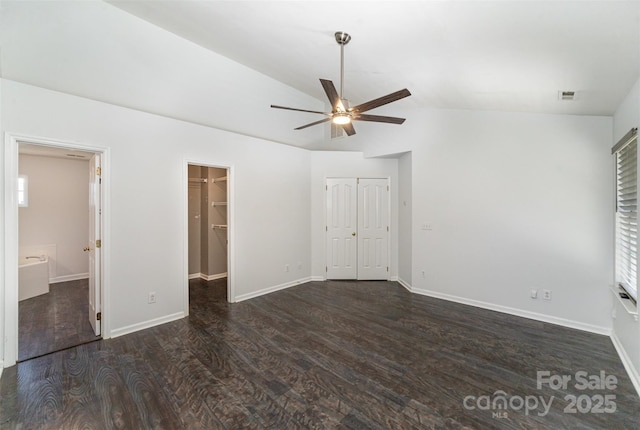 unfurnished bedroom with dark wood-type flooring, vaulted ceiling, ensuite bath, and ceiling fan