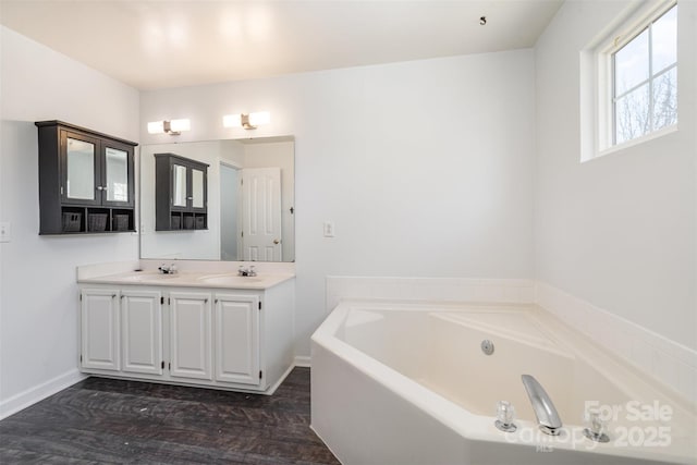 bathroom with vanity, wood-type flooring, and a tub to relax in