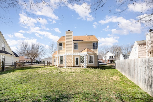 rear view of house featuring a yard and a pergola