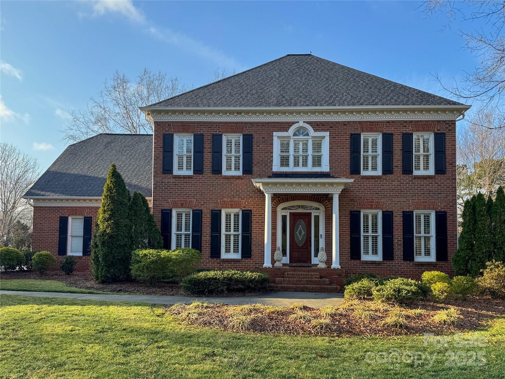 colonial house featuring a front lawn