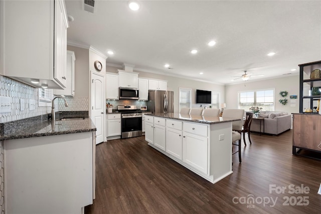 kitchen featuring appliances with stainless steel finishes, sink, a kitchen island, and white cabinets