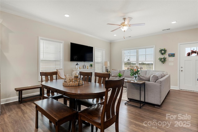 dining area with ornamental molding, ceiling fan, and dark hardwood / wood-style flooring