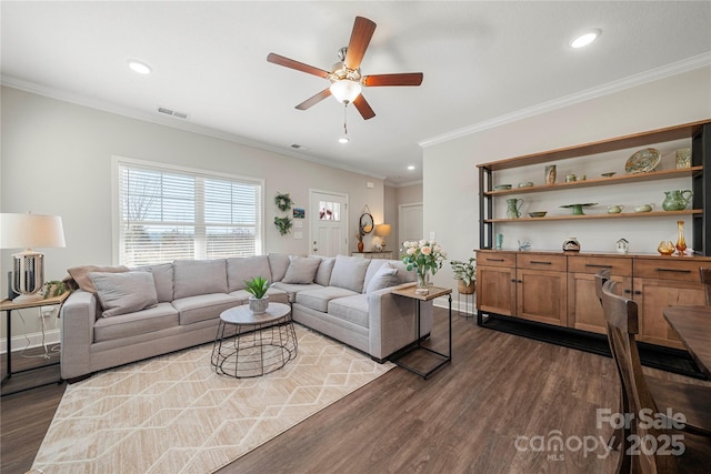 living room featuring ceiling fan, ornamental molding, and dark hardwood / wood-style floors