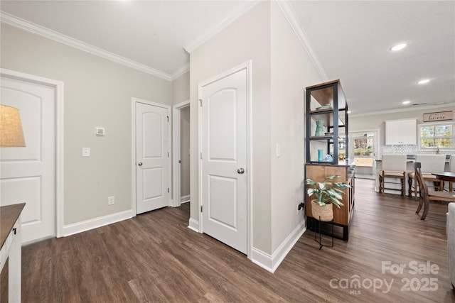 corridor with ornamental molding and dark hardwood / wood-style flooring