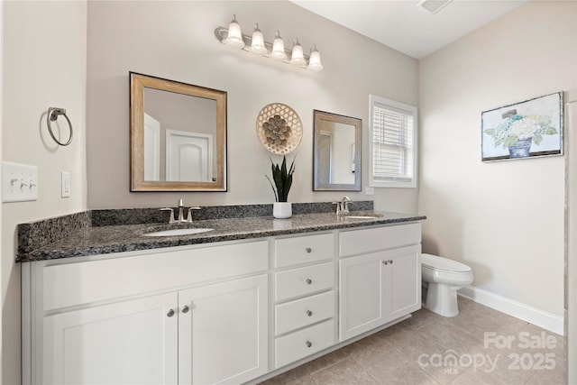 bathroom featuring vanity, tile patterned floors, and toilet