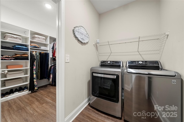 clothes washing area featuring wood-type flooring and washer and dryer