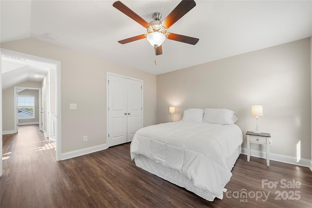 bedroom featuring vaulted ceiling, dark hardwood / wood-style floors, ceiling fan, and a closet